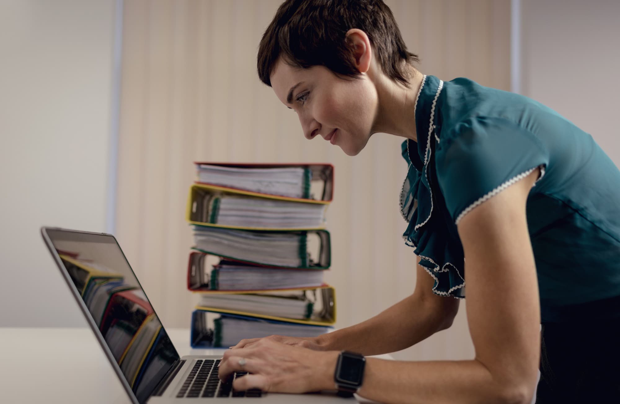 Professional using a laptop with organized files nearby