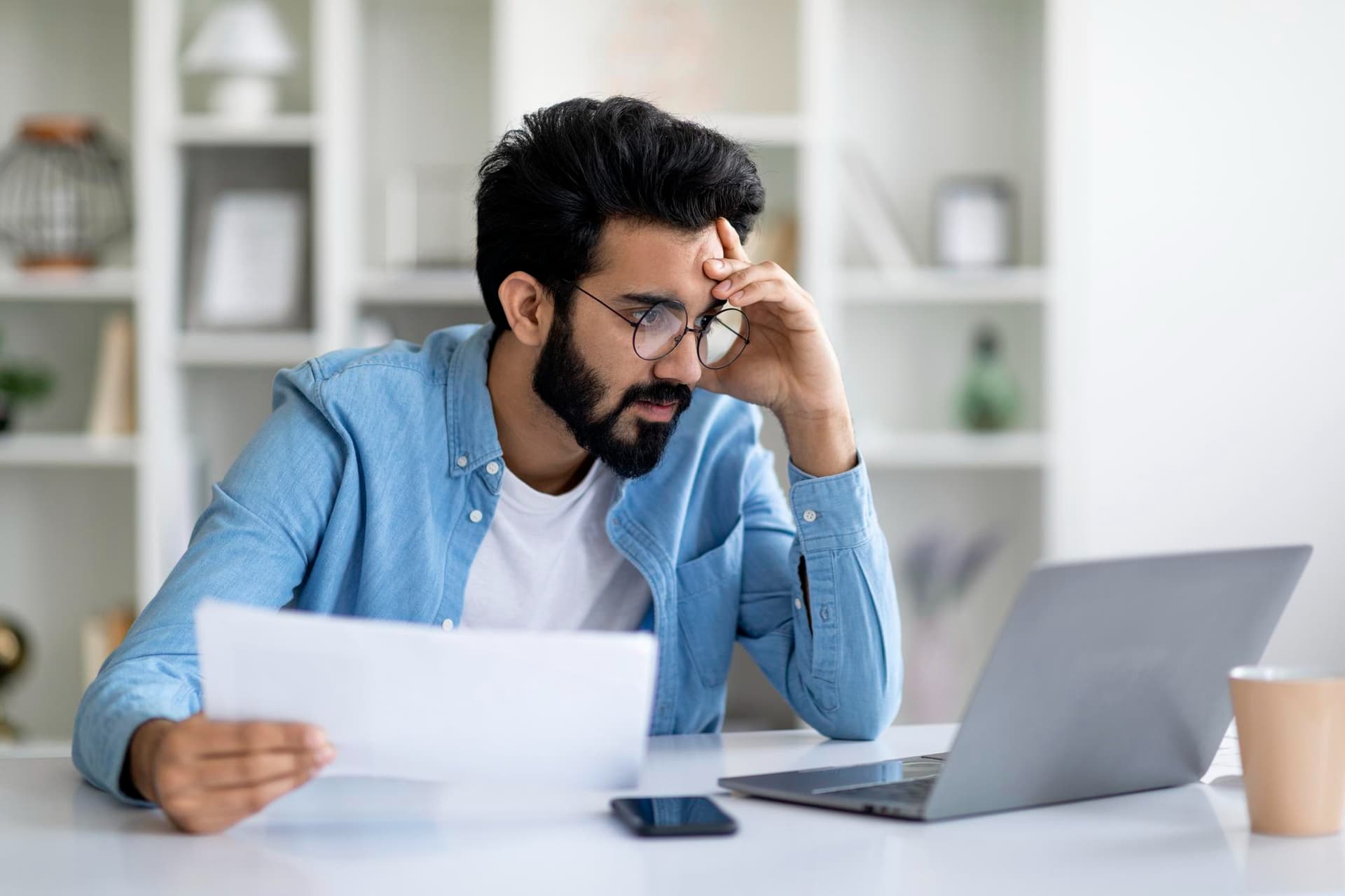 Professional reviewing ACA reporting documents at a laptop