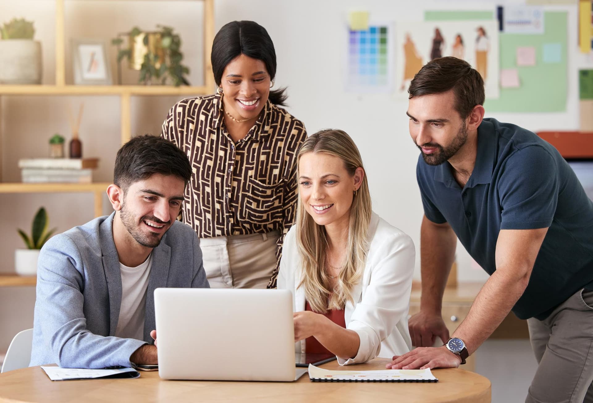 Team collaborating around a laptop